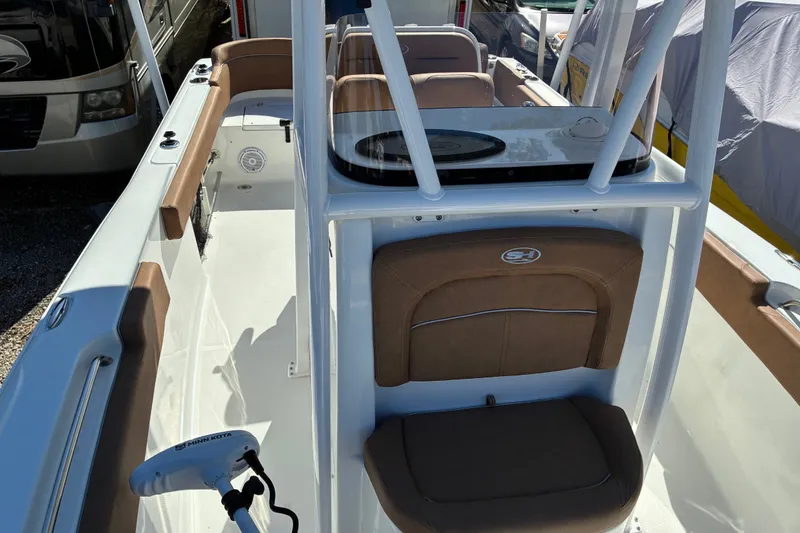 Slide: The Image of 2023 Sea Hunt Ultra 229 boat interior with brown seating and white console. - 29