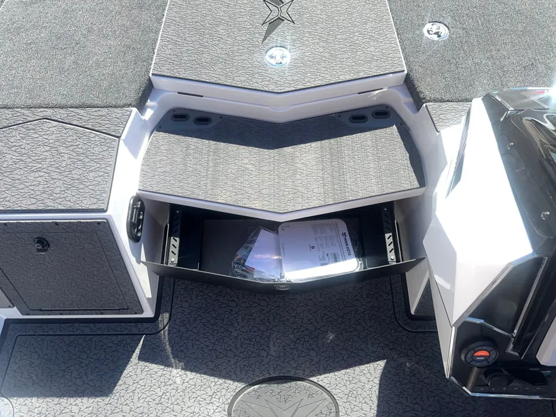 Slide: The Image of The image shows the deck of a 2027 Vexus VXs21 boat with storage and gray carpeting. - 4