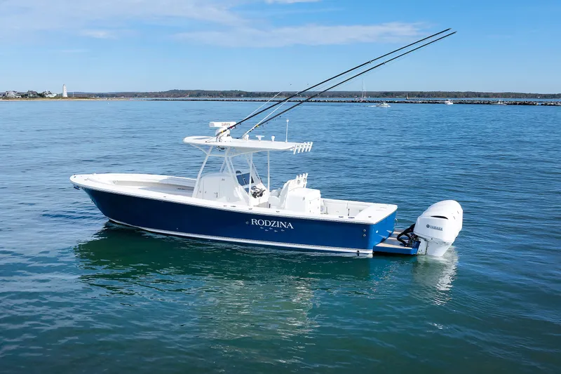 Slide: The Image of A 2018 Regulator 34SS boat on calm water with two outboard engines and fishing rods. - 7