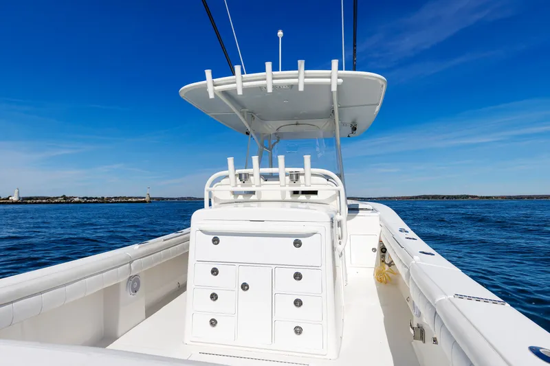 Slide: The Image of A 2018 Regulator 34SS boat on calm water. It features a central console and multiple storage compartments. - 27