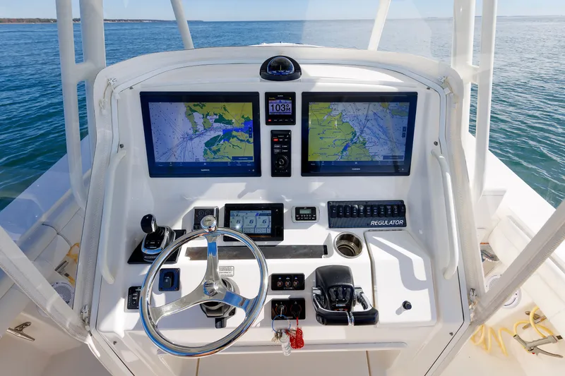 Slide: The Image of The image shows the helm of a 2018 Regulator 34SS boat with two large screens. - 21