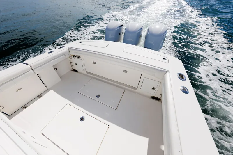 Slide: The Image of The image shows the stern of a 2018 Regulator 34SS boat with three outboard engines. - 28