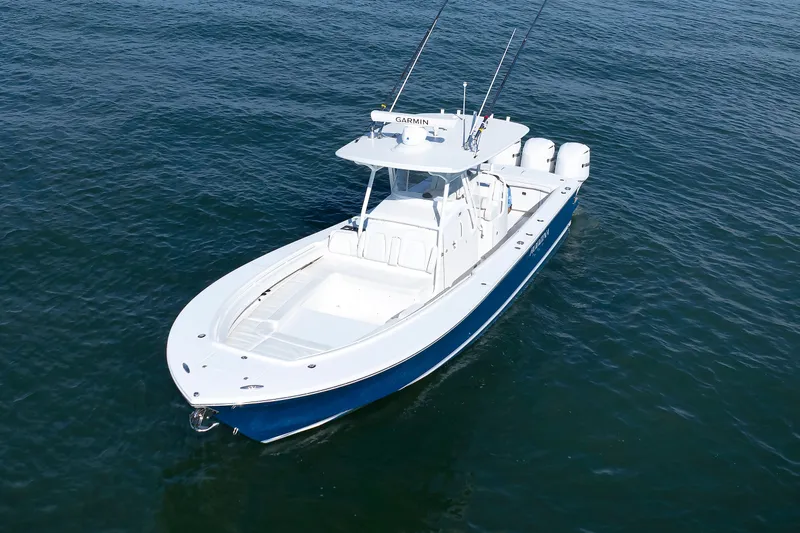 Slide: The Image of A 2018 Regulator 34SS boat on calm water, featuring a blue hull and three outboard engines. - 5