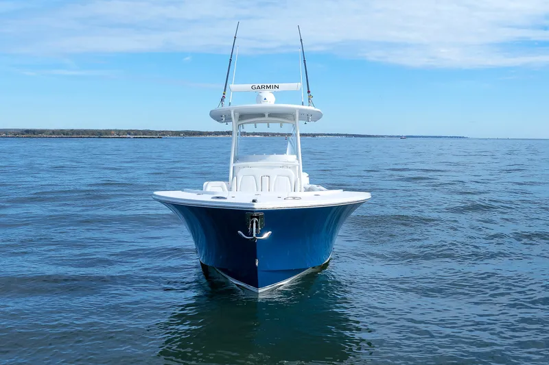 Slide: The Image of A 2018 Regulator 34SS boat on calm water with a blue hull and Garmin equipment. - 10