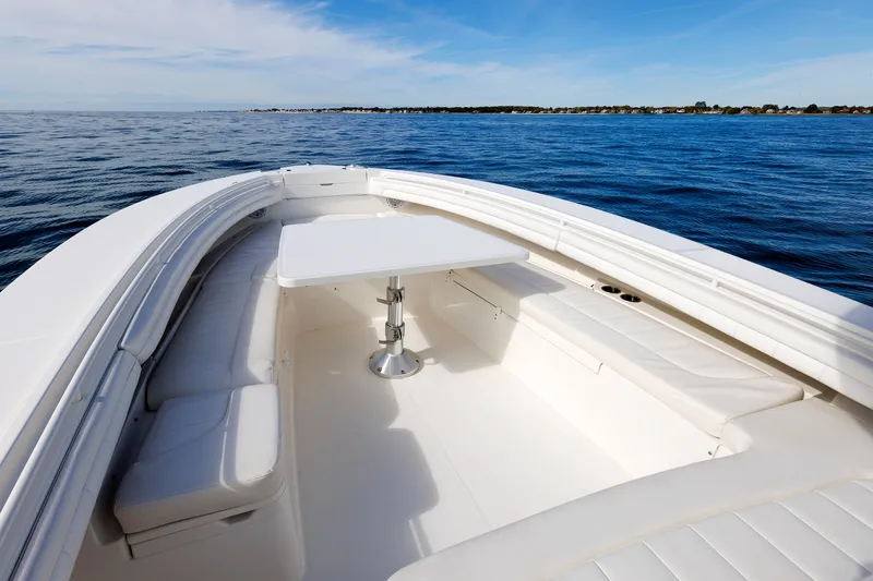 Slide: The Image of The image shows the bow of a 2018 Regulator 34SS boat with white seating and a table. - 12