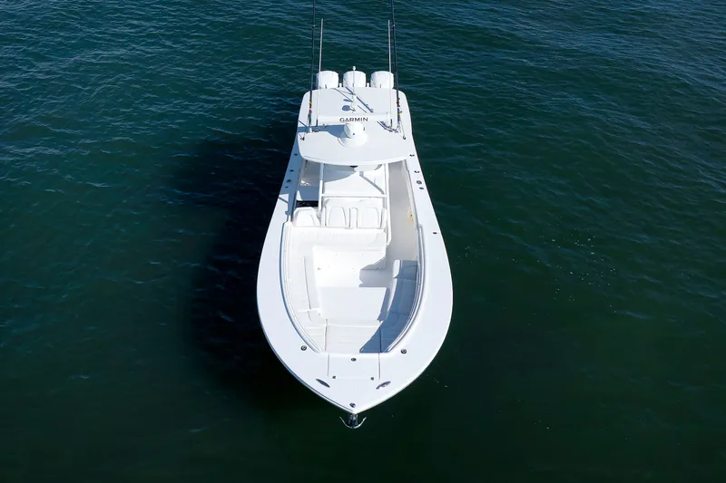 Slide: The Image of A white boat floating on calm water, featuring a spacious deck and two engines. - 4