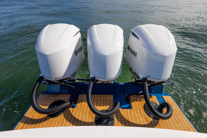 Slide: The Image of Three Yamaha outboard engines are mounted on a boat floating on calm water. - 33