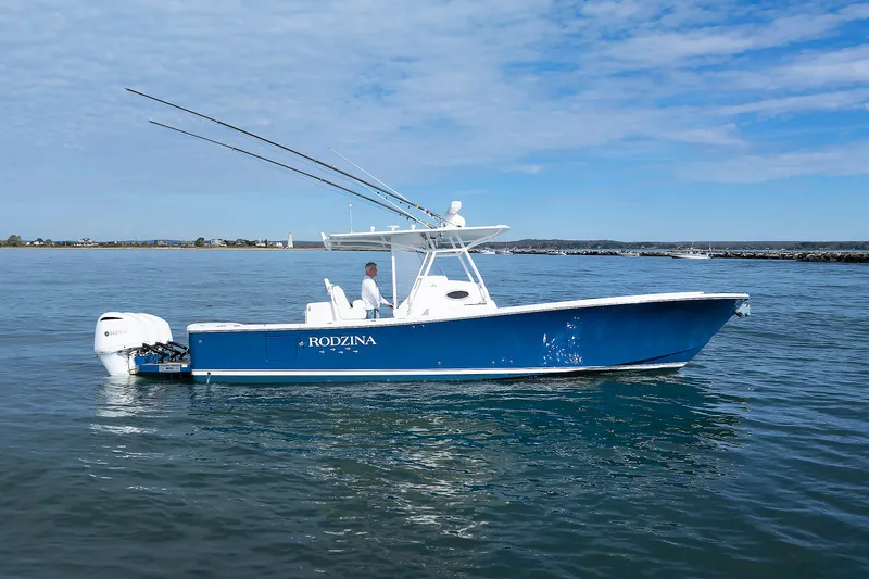 Slide: The Image of A blue boat cruising on calm water, featuring two outboard engines and one person on board. - 9