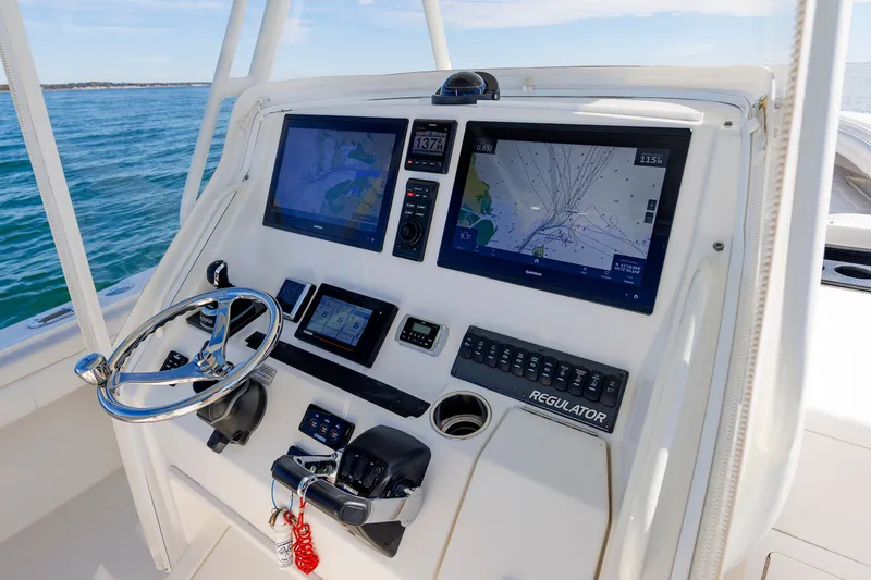 Slide: The Image of The image shows the helm of a 2018 Regulator 34SS boat with two large screens. - 20