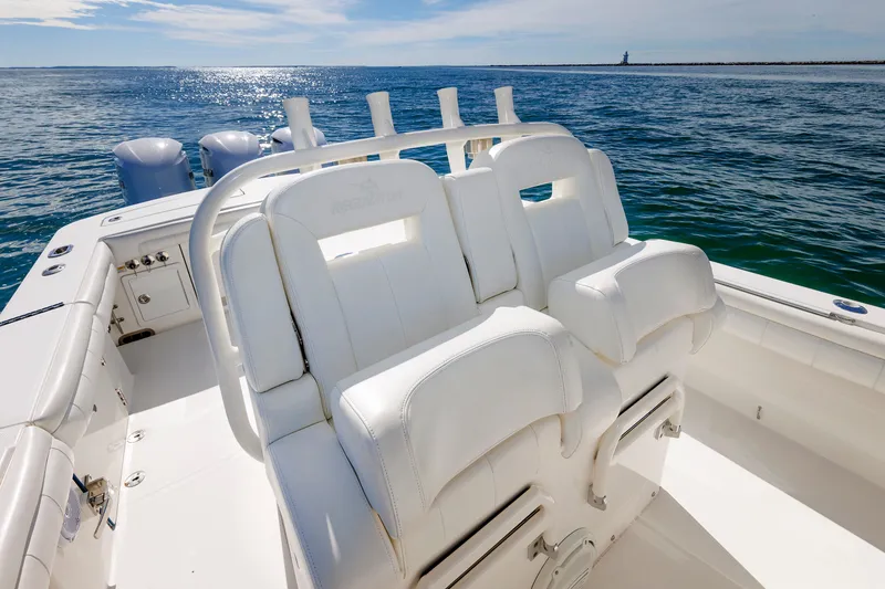 Slide: The Image of A 2018 Regulator 34SS boat with white seating and multiple outboard engines on calm water. - 23
