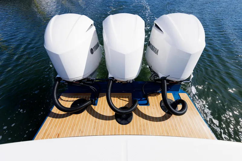 Slide: The Image of Three Yamaha outboard engines on a Regulator 34SS boat, on calm water. - 34