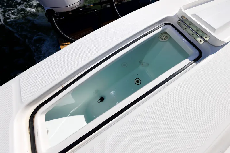 Slide: The Image of A livewell on a 2018 Regulator 34SS boat, filled with water, surrounded by white decking. - 37