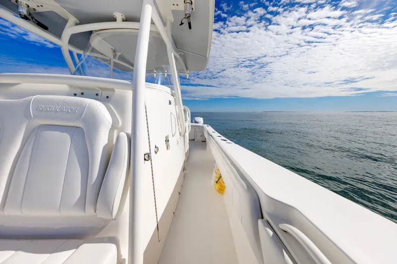 Slide: The Image of A 2018 Regulator 34SS boat on the water with a clear blue sky and white clouds. - 15