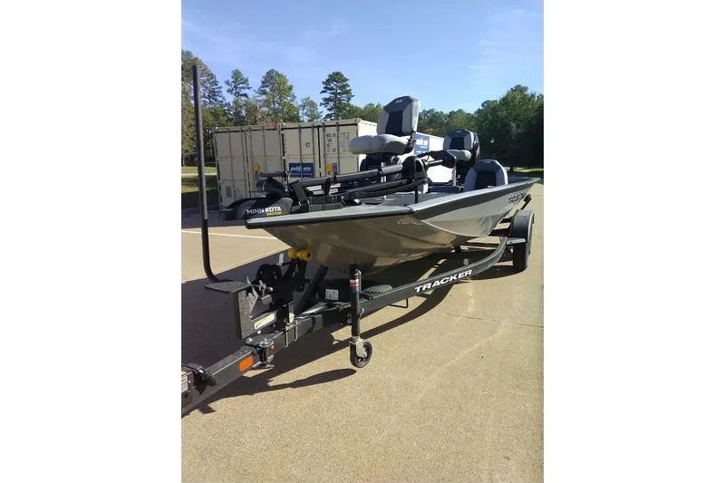 The Image of 2027 Tracker Pro Team 195 boat on trailer, parked outdoors under clear sky. - 0