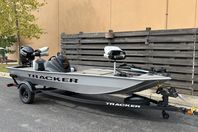 The Image of 2027 Tracker Pro 170 fishing boat on trailer, parked outdoors near wooden fence. - 0