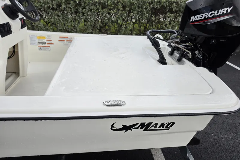 Slide: The Image of 2026 Mako Pro Skiff 13 CC boat with Mercury engine, parked outdoors. - 10