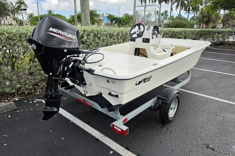 Slide: The Image of 2026 Mako Pro Skiff 13 CC boat with Mercury engine on trailer in parking lot. - 7