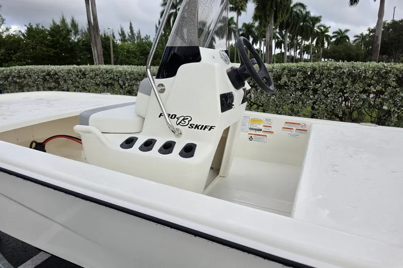 Slide: The Image of 2026 Mako Pro Skiff 13 CC boat with steering console, outdoors. - 6