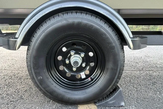 Slide: The Image of Trailer wheel of 2027 Tracker Grizzly 1654 T Sportsman on asphalt surface. - 22