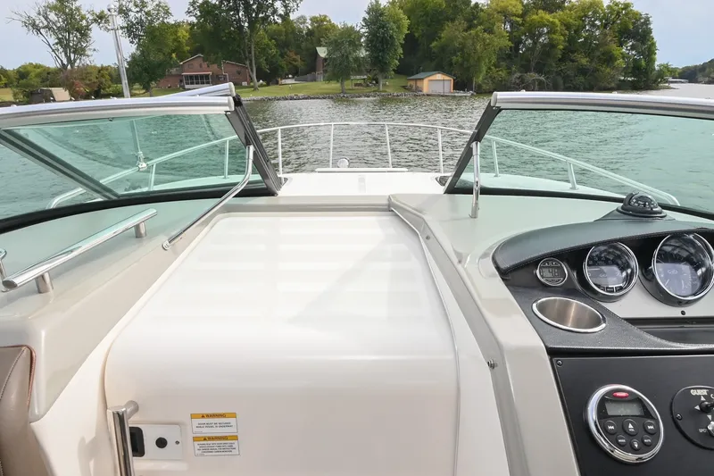 Slide: The Image of 2014 Sea Ray Sundancer 260 dashboard view, featuring sleek controls and scenic water backdrop. - 35