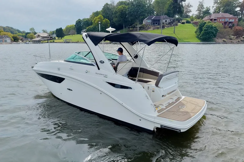 Slide: The Image of 2014 Sea Ray Sundancer 260 cruising on a scenic lake with lush green surroundings. - 16