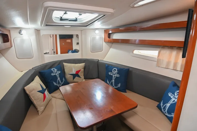 Slide: The Image of Interior of 2014 Sea Ray Sundancer 260 with cozy seating and nautical-themed cushions. - 45