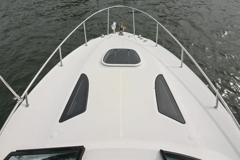 Slide: The Image of Bow view of 2014 Sea Ray Sundancer 260 on water, showcasing sleek design. - 37