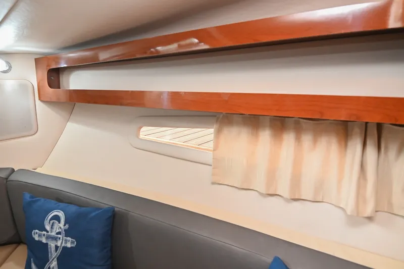 Slide: The Image of Interior of 2014 Sea Ray Sundancer 260 with wooden trim and nautical-themed pillow. - 52
