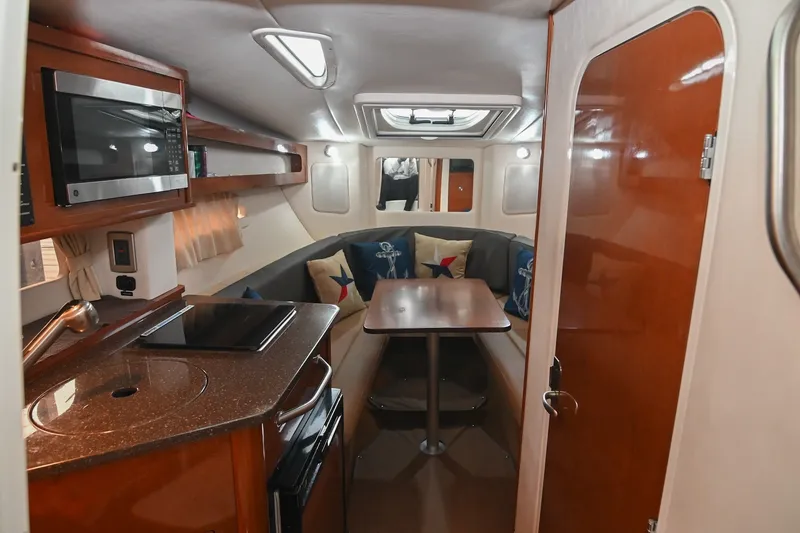 Slide: The Image of Interior of 2014 Sea Ray Sundancer 260, featuring kitchenette and cozy dining area. - 39