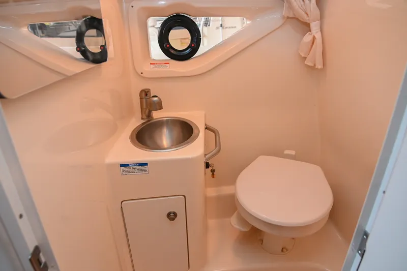 Slide: The Image of 2014 Sea Ray Sundancer 260 bathroom with sink, toilet, and porthole window. - 55