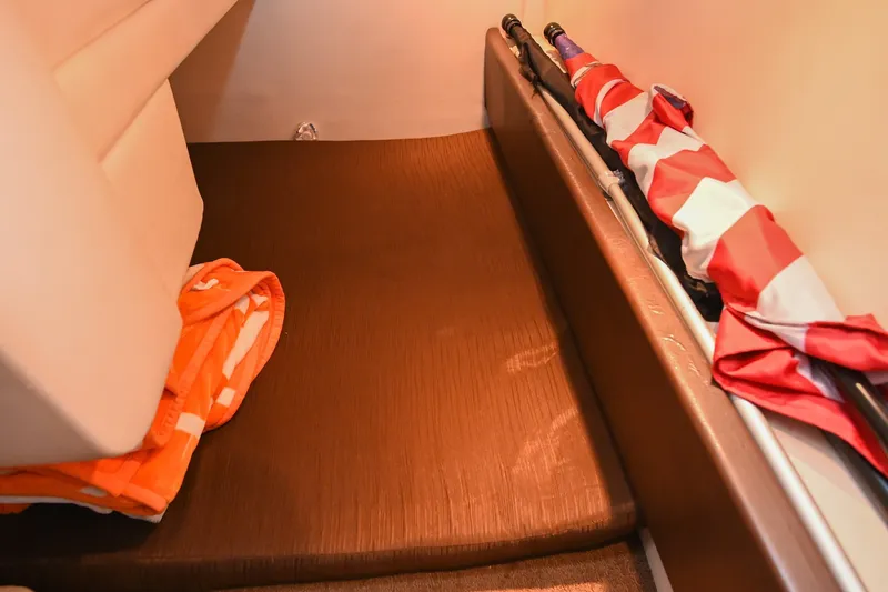 Slide: The Image of 2014 Sea Ray Sundancer 260 cabin interior with folded orange towel and stored flag. - 57