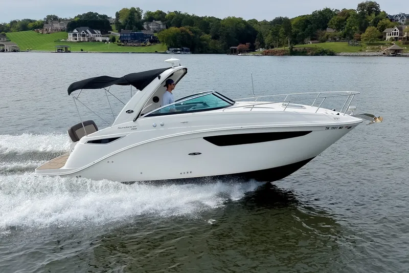 Slide: The Image of 2014 Sea Ray Sundancer 260 cruising on a scenic lake with lush green shoreline. - 61