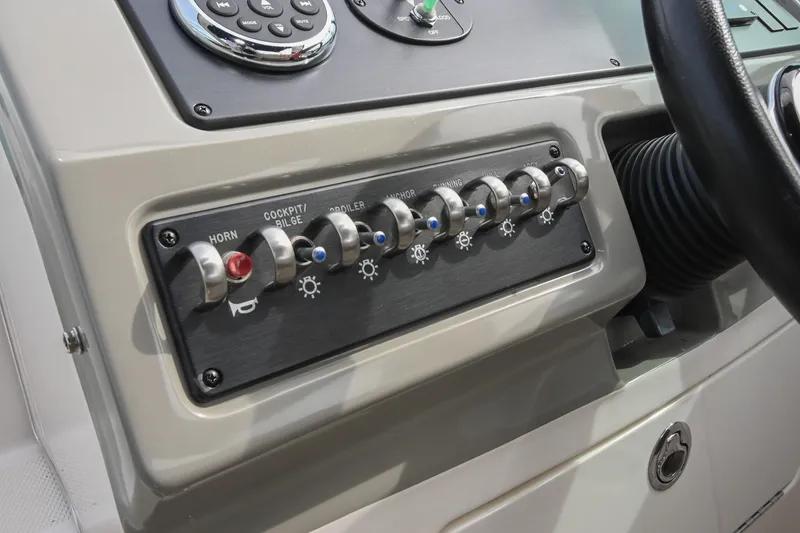 Slide: The Image of Control panel of a 2014 Sea Ray Sundancer 260 boat with switches and buttons. - 33