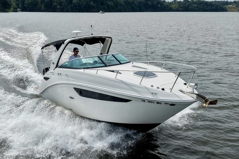The Image of 2014 Sea Ray Sundancer 260 cruising on a lake, creating a dynamic water wake. - 0