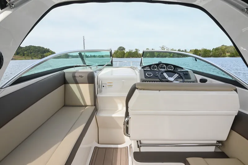 Slide: The Image of Interior view of 2014 Sea Ray Sundancer 260 boat, featuring helm and seating area on a lake. - 27