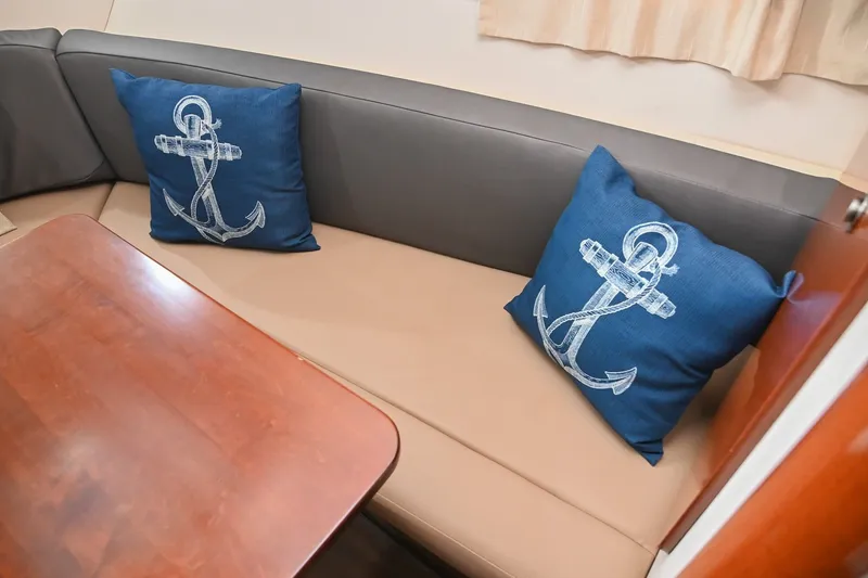 Slide: The Image of Interior of 2014 Sea Ray Sundancer 260 with anchor-themed cushions on a beige sofa. - 49