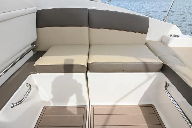 Slide: The Image of 2014 Sea Ray Sundancer 260 boat seating area with beige and gray cushions. - 26