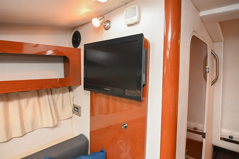 Slide: The Image of Interior of 2014 Sea Ray Sundancer 260 with mounted TV and wooden accents. - 53