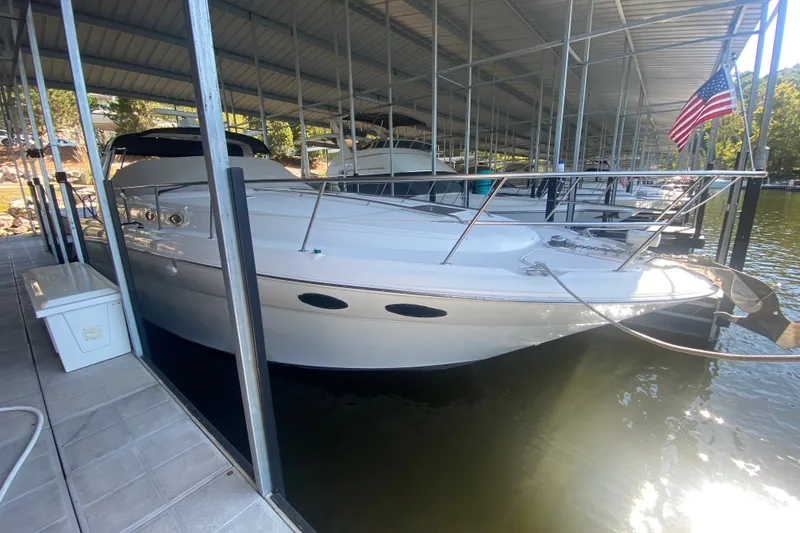 Slide: The Image of 1999 Sea Ray 380 Sundancer docked under a covered marina with an American flag. - 7
