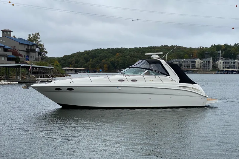 Slide: The Image of 1999 Sea Ray 380 Sundancer yacht on a calm lake with scenic background. - 9
