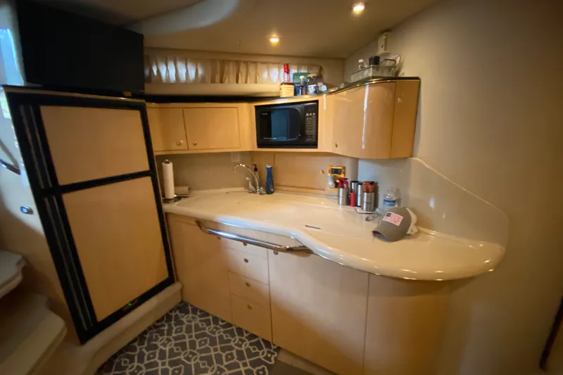 Slide: The Image of 1999 Sea Ray 380 Sundancer kitchen with modern amenities and sleek cabinetry. - 32