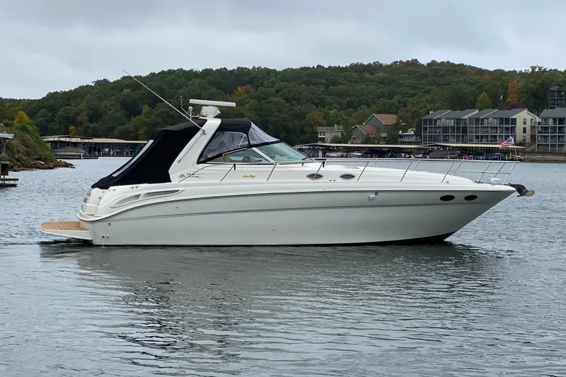 Slide: The Image of 1999 Sea Ray 380 Sundancer yacht on a calm lake with scenic background. - 4