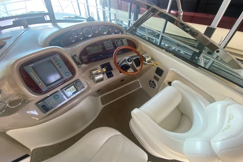 Slide: The Image of Cockpit of 1999 Sea Ray 380 Sundancer with steering wheel and navigation controls. - 16
