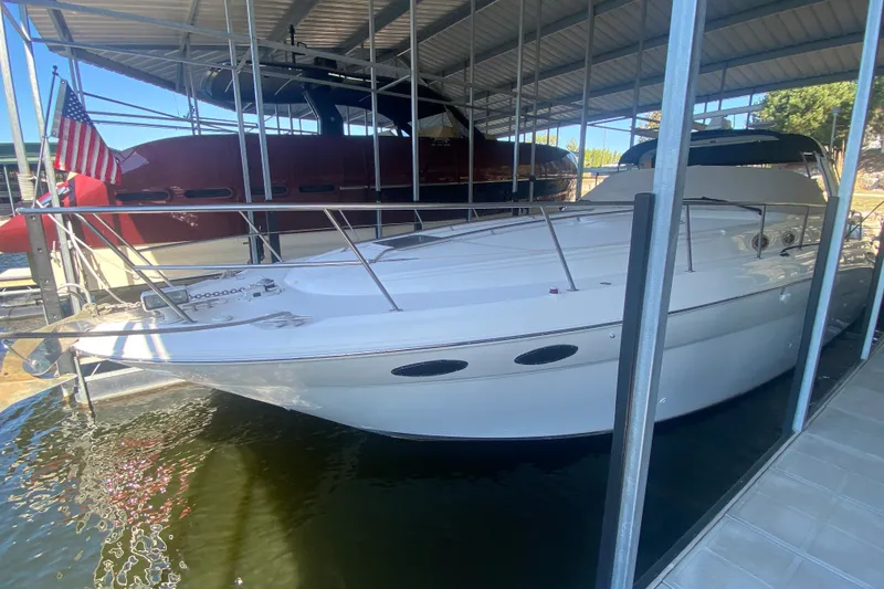 Slide: The Image of 1999 Sea Ray 380 Sundancer docked under a covered marina with American flag. - 12