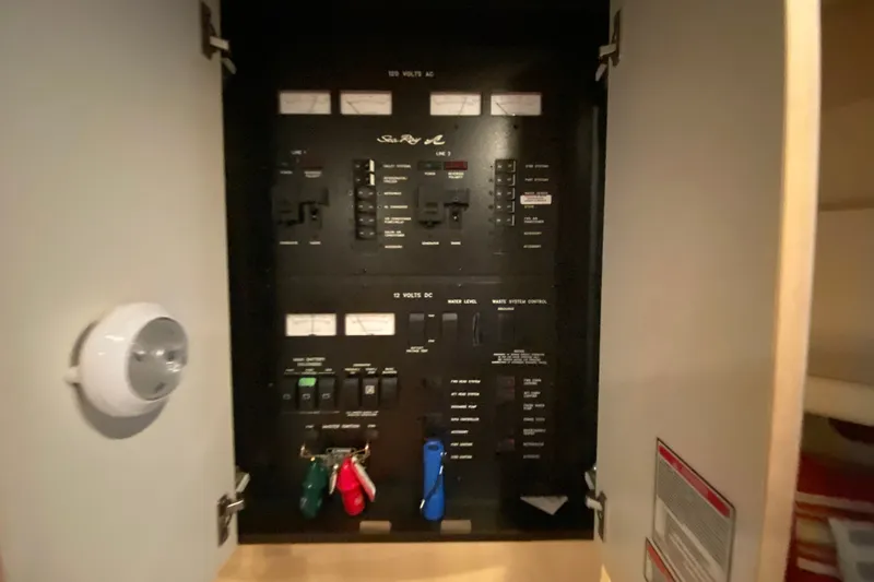 Slide: The Image of Electrical panel inside 1999 Sea Ray 380 Sundancer boat, showing switches and meters. - 28