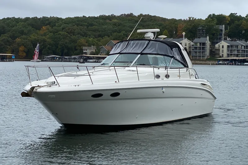 Slide: The Image of 1999 Sea Ray 380 Sundancer yacht on a serene lake with forested shoreline. - 3