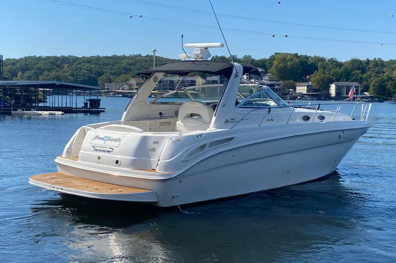 Slide: The Image of 1999 Sea Ray 380 Sundancer yacht on a serene lake with wooded shoreline. - 5