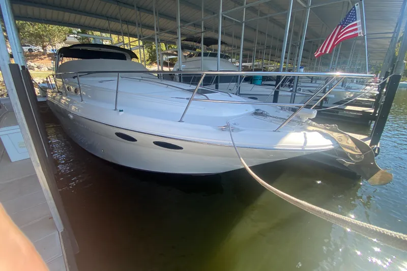 Slide: The Image of 1999 Sea Ray 380 Sundancer docked under a covered marina with American flag. - 8
