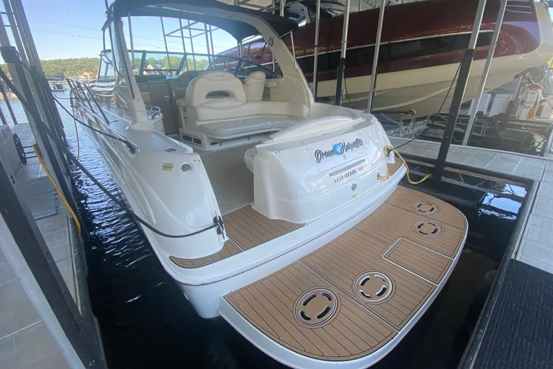 Slide: The Image of 1999 Sea Ray 380 Sundancer docked, featuring spacious deck and seating area. - 13