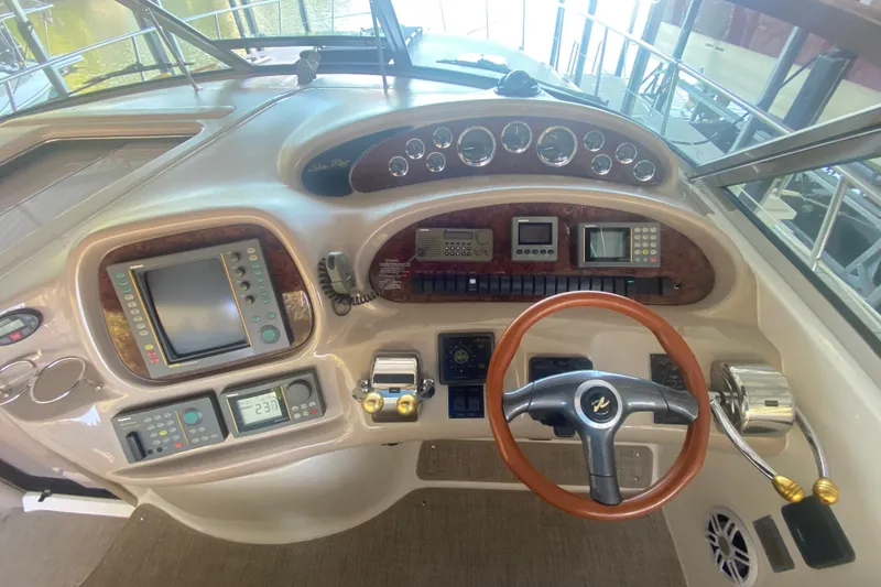 Slide: The Image of Control panel of a 1999 Sea Ray 380 Sundancer boat with steering wheel and navigation instruments. - 23